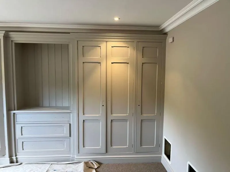 Fitted wardrobe and cabinetry freshly refinished in soft grey by Martin And Co. Decorating, Surrey