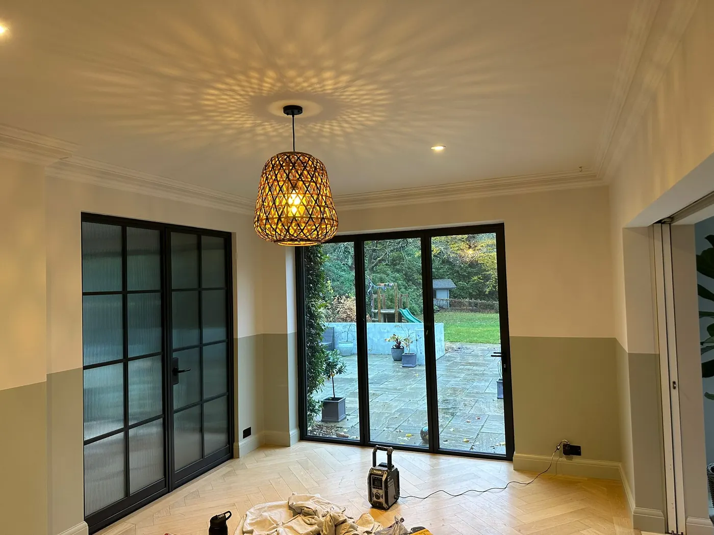 Freshly painted two-tone living space with sage green and cream walls and glazed garden doors, finished by Martin And Co. Decorating